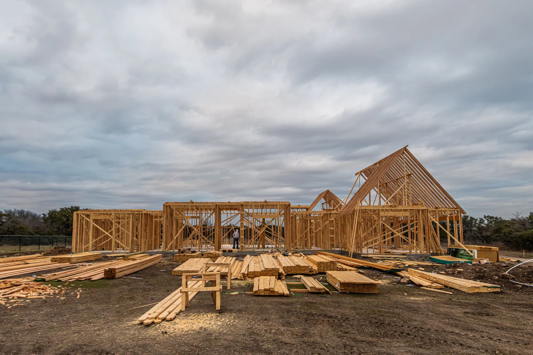 Timber framing and stacks of lumber at a residential construction site in Fort Worth, Texas